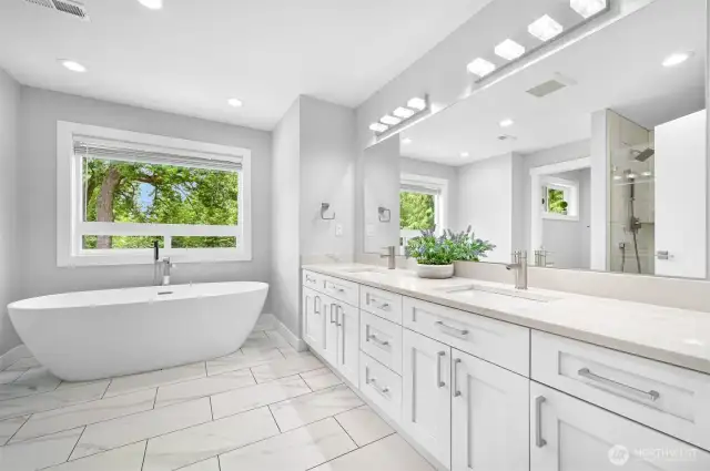 Tiled and heated floors, oversized double vanity and a soaking tub with a view of the trees.