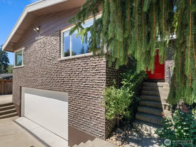 Home's elevation showcases mid-century modern architectural touches, brick with weeping mortar & cedar wood
