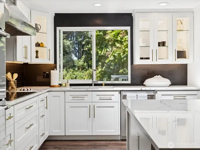 Beautiful basalt backsplash & built-in lighted & soft-close cabinetry that features incredible storage options