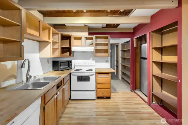 Lower level full kitchen. The hallway leads to the bathroom, laundry, and garage.