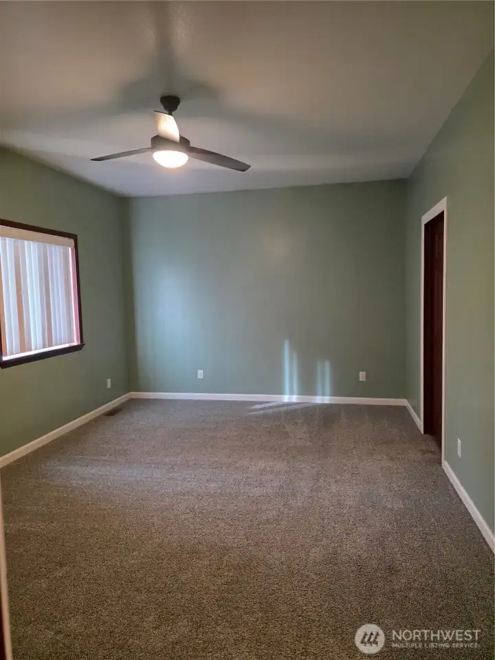 Large primary bedroom with a ceiling fan.