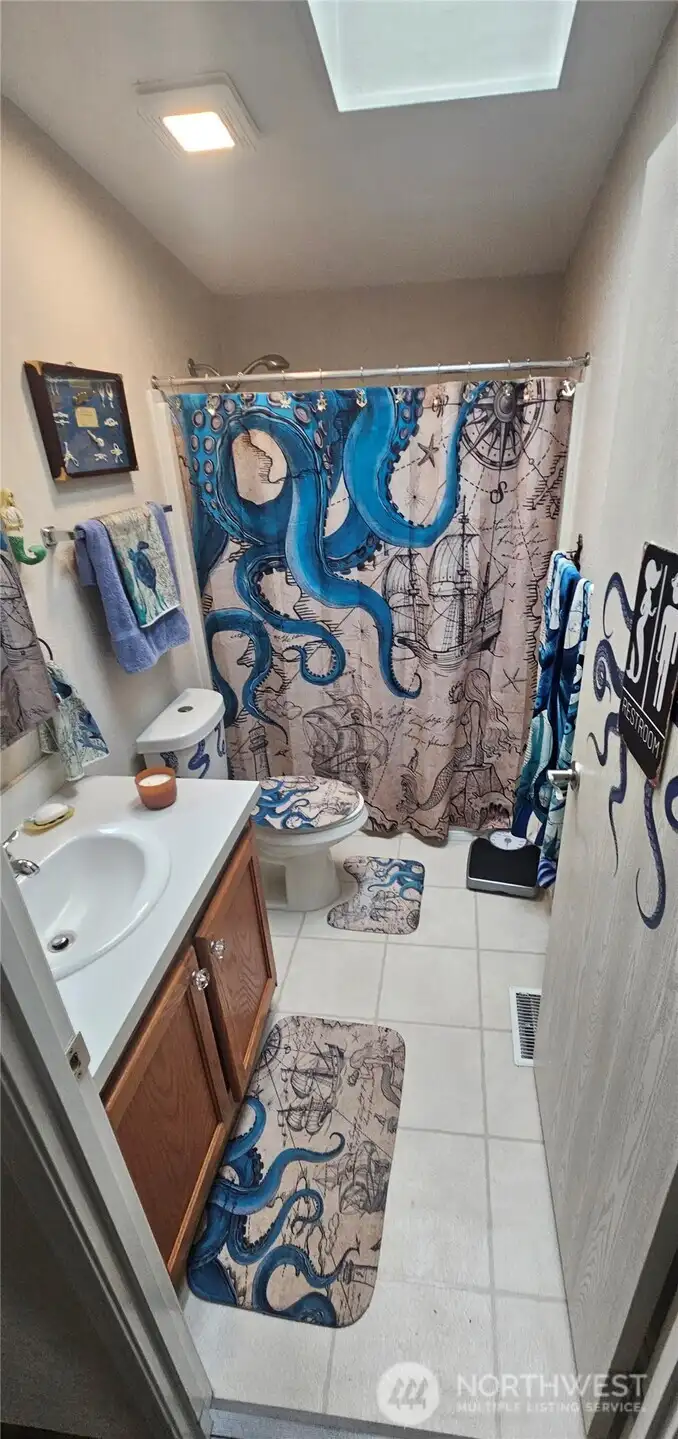Full sized guest bathroom with a great skylight for natural light.