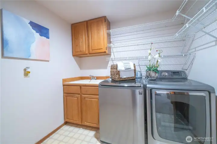 Upper-level utility room with sink.  Appliances are included.
