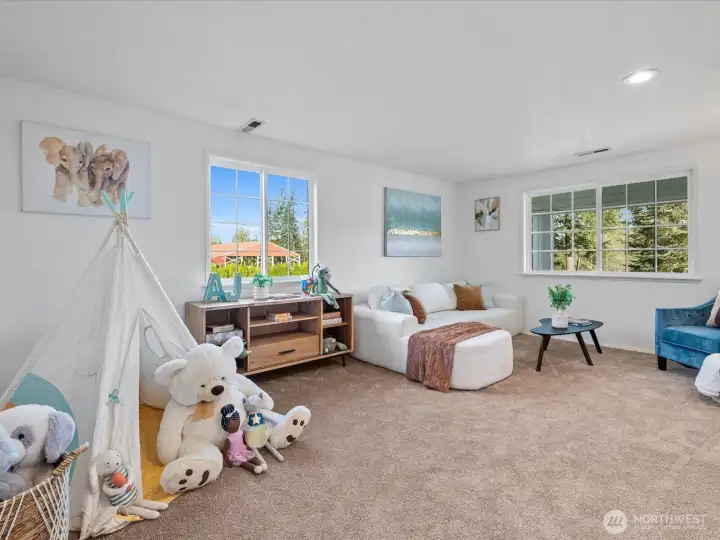 Spacious bonus/playroom or 5th bedroom with large windows, offering flexible use for media, recreation, or additional living space.