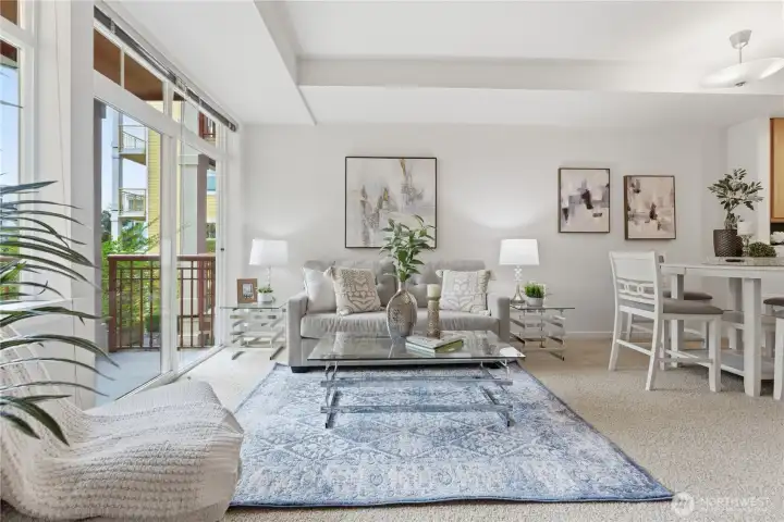 Light-filled living room where soft textures meet a wall of windows leading out to the balcony and greenery