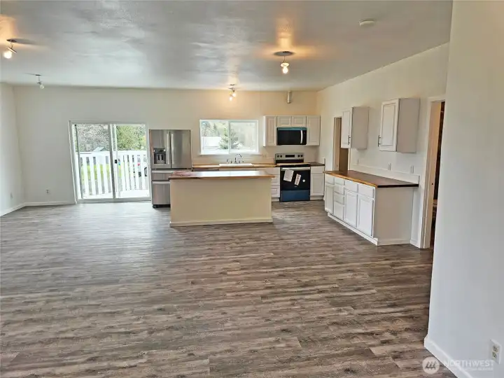 Great Room open to the kitchen area. EZ clean and durable vinyl plank flooring.