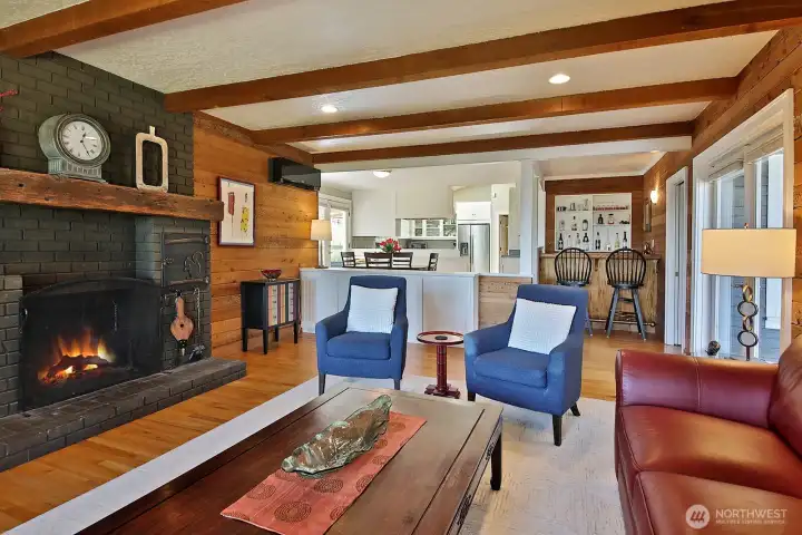 View of the family room, with wood fireplace, looking back towards the kitchen with dining area and wet bar. Another set of French doors connects you to the spacious deck. There is room for everyone in this home! View of the family room, with wood fireplace, looking back towards the kitchen with dining area and wet bar. Another set of French doors connects you to the spacious deck. There is room for everyone in this home!