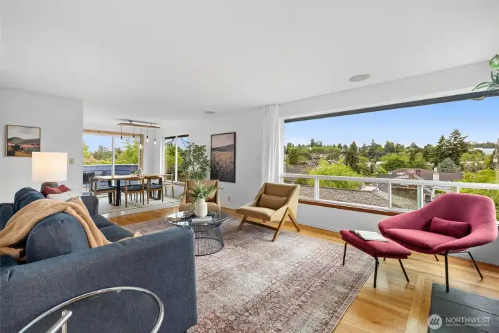 Light filled, wall of   windows frame sweeping views across Columbia City, bringing in natural light and creating  a feeling of connection to the surrounding landscape.