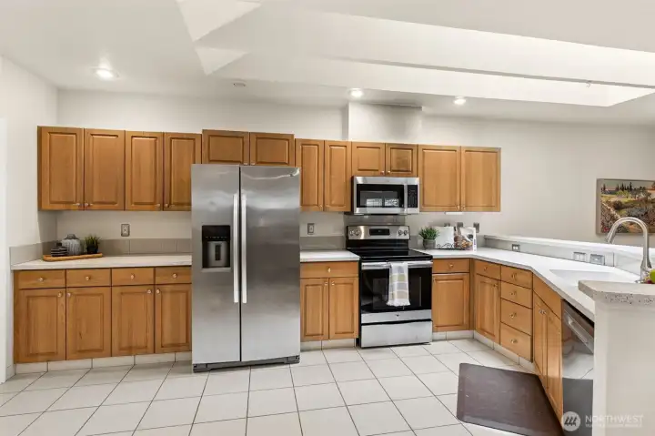 The well-designed kitchen offers a separate baking center/bar area for more than one cooking activity at a time. Upgraded stainless appliances and corian counters enjoy loads of natural light from two large skylights overhead. The well-designed kitchen offers a separate baking center/bar area for more than one cooking activity at a time. Upgraded stainless appliances and corian counters enjoy loads of natural light from two large skylights overhead.