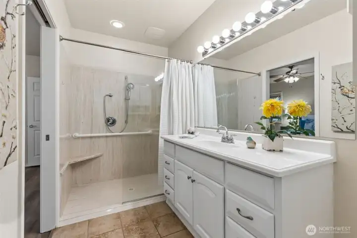 The upgraded primary bathroom includes a large, wide, low-rise shower with grab bar, bench and shower wand. An extra wide, large vanity offers plenty of storage too. The upgraded primary bathroom includes a large, wide, low-rise shower with grab bar, bench and shower wand. An extra wide, large vanity offers plenty of storage too.