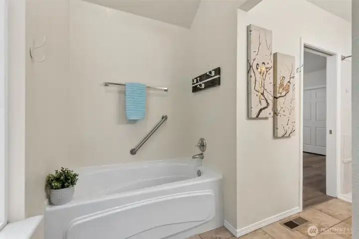 Retreat to the soaking tub alcove in the primary bath, across from the toilet. High ceilings and a cathedral style window wait for your spa decor. RELAX! Retreat to the soaking tub alcove in the primary bath, across from the toilet. High ceilings and a cathedral style window wait for your spa decor. RELAX!