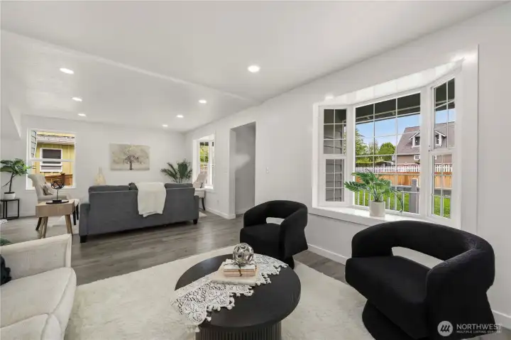 This angle highlights the spacious living room, charming bay windows, covered front deck, and new front fencing.