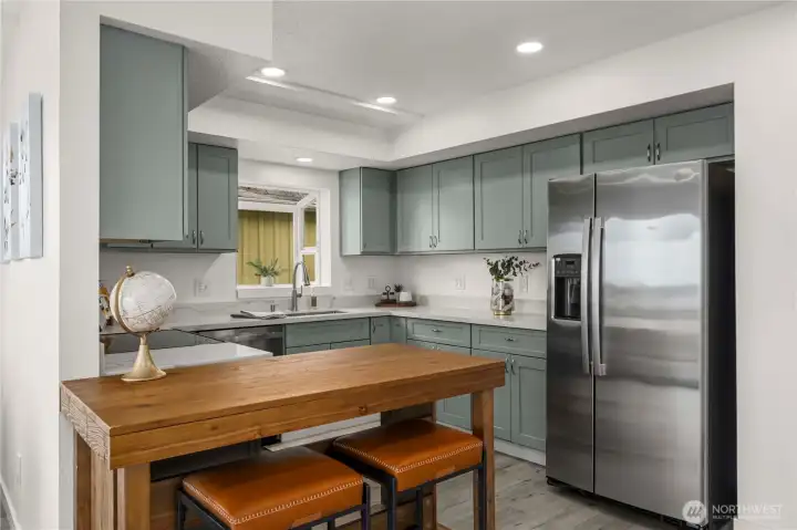 Spacious updated kitchen showcases modern finishes, plentiful storage, and a flexible layout that can easily accommodate a more open dining configuration. Includes a walk-in pantry not pictured.
