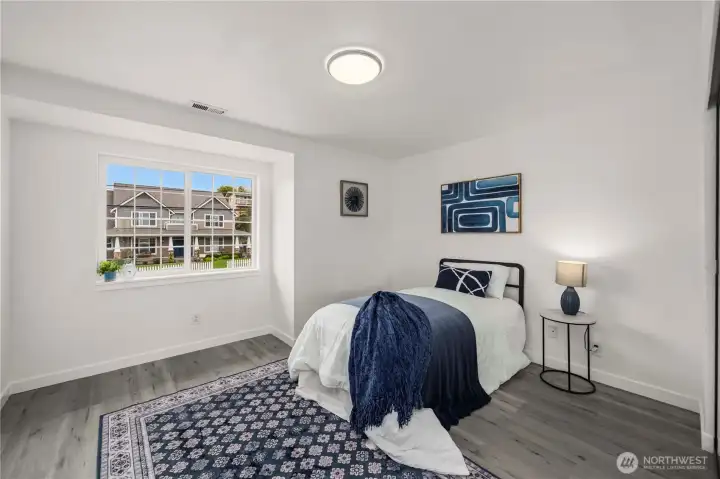 Well-sized upstairs bedroom featuring updated flooring, bright interiors, and a warm inviting feel.