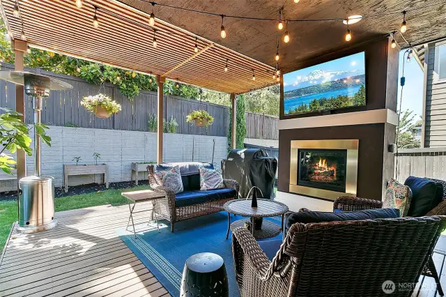 Serene outdoor deck area with gas fireplace and TV.