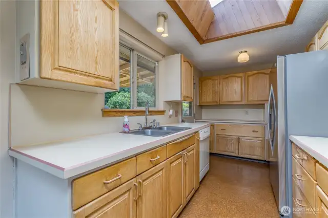 Kitchen is bathed in light with the large skylight