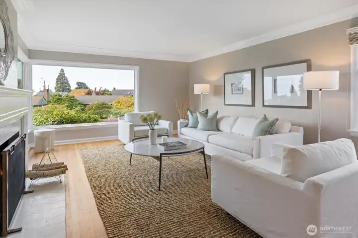 The charming wood-burning fireplace with classic 1940’s detailing, including a crisp painted mantel, fluted millwork, and timeless crown moldings—anchor the living room with warmth and character.