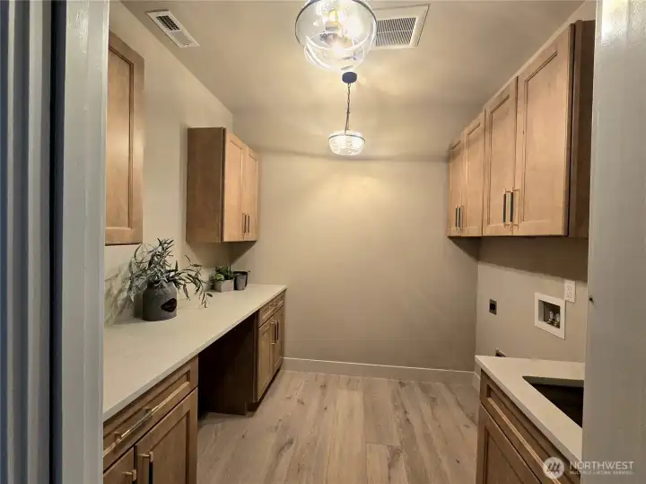 Conveniently located laundry with lots of storage and work space