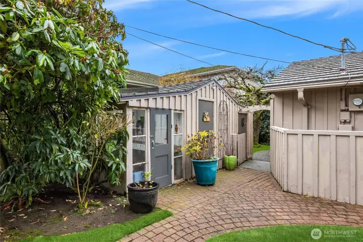 A potting/storage "shed" is quietly tucked behind the main home.