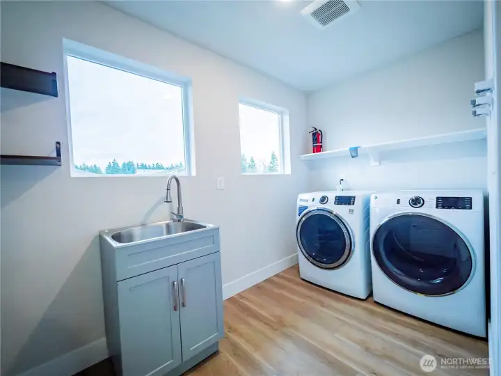 BIG LAUNDRY ROOM ON SECOND FLOOR WITH SHELVING AND UTILITY SINK