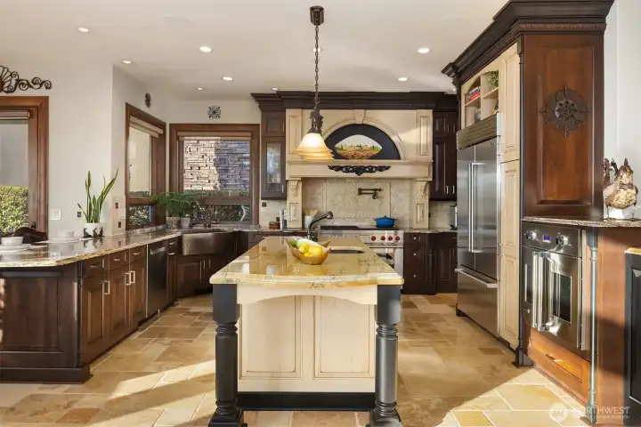 A gourmet kitchen is masterclass in refined design and professional-grade performance. It blends beauty and function with granite countertops and custom backsplash and Bellmont 1900 cherry wood cabinetry.
