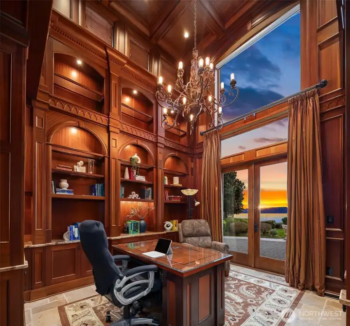 The two-story library here showcases true craftsmanship and warmth, wrapped entirely in floor to ceiling rich Sapele wood shelving and cabinetry with custom ebony inlays.