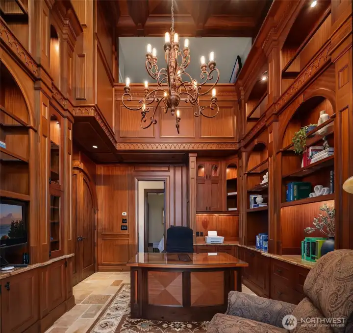 The two-story library here showcases true craftmanship and warmth, wrapped entirely in floor to ceiling rich Sapele wood shelving and cabinetry with custom ebony inlays. Additionally, there is built-in sound, TV and French doors that open to the rear patio.
