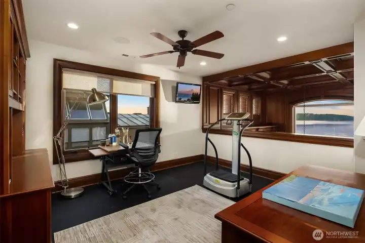 Exercise room overlooks the library with sound system zone, TV and an incredible view of the Puget Sound.