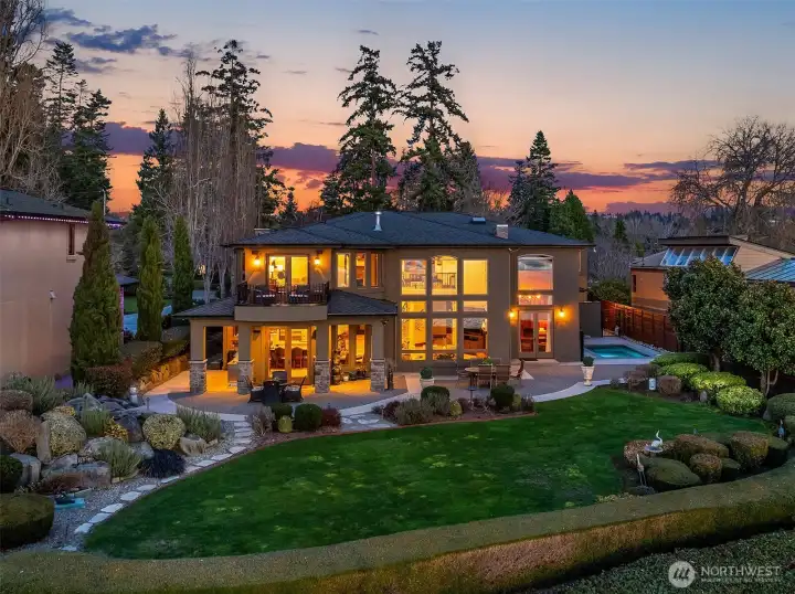 This backyard oasis resembles a resort with water features, firepit, custom paver patio, outdoor kitchen with all the bells and whistles, surrounded by english gardens.