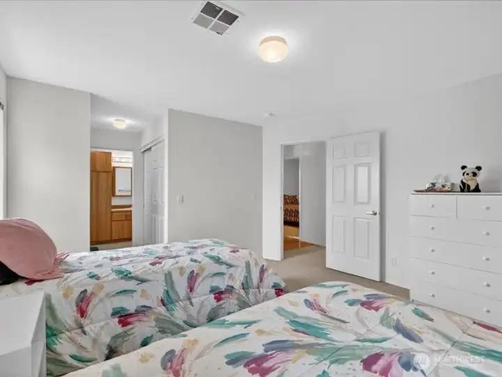 Looking across the primary suite with the full bath to the left and the 2nd bedroom across the hallway. Looking across the primary suite with the full bath to the left and the 2nd bedroom across the hallway.