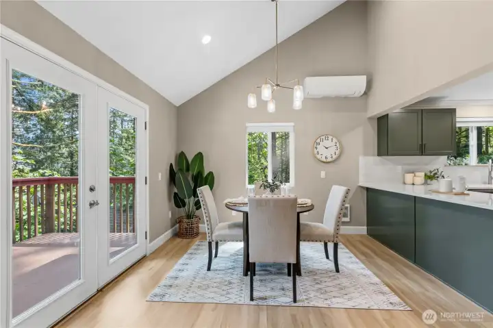 Open-concept living and dining spaces with vaulted ceilings, natural light, and direct access to the deck for indoor-outdoor living.