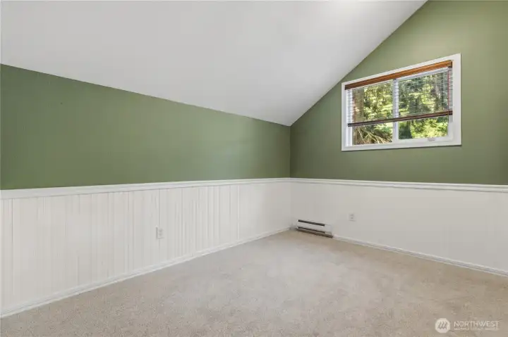 Third bedroom on the upper-level with updated flooring, custom wall detail, and peaceful wooded outlooks.