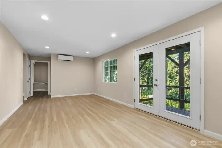 Expansive lower-level living area with recessed lighting, durable flooring, and direct access to the covered outdoor space.