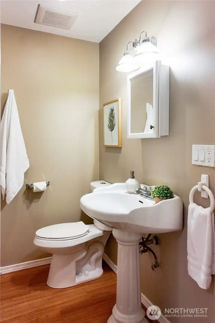 Convenient lower-level bathroom with pedestal sink and updated lighting.