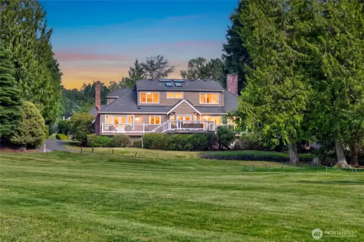 Back exterior with an expansive deck overlooking the fairway. Resort living at its finest!
