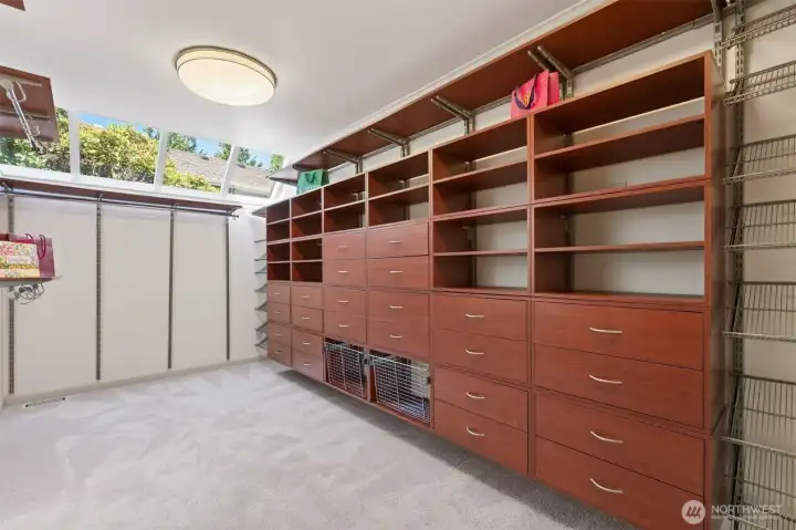 Primary walk-in closet with skylights and custom closet system.