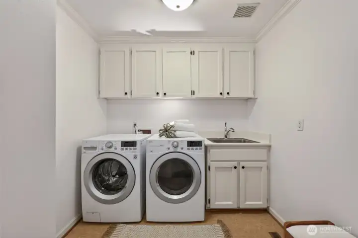 Convenient mud room & laundry room with utility sink and extra large cabinetry spaces