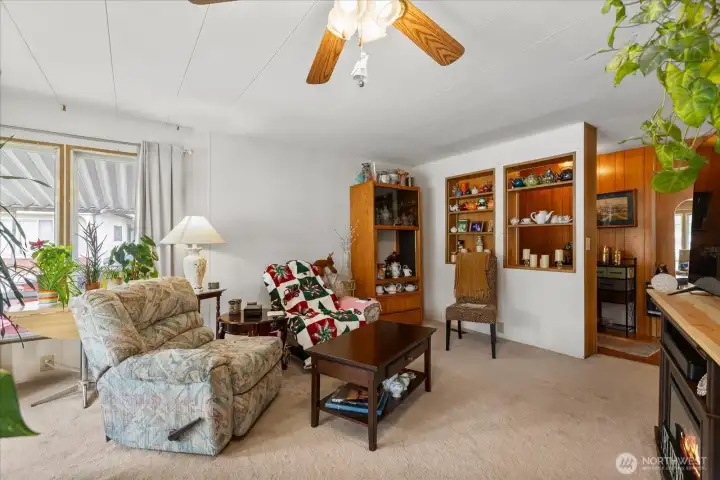 Spacious living room featuring large windows and classic custom built-ins.