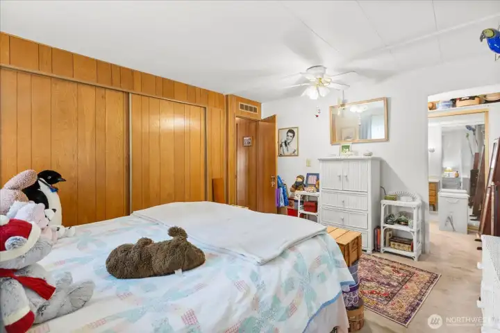 Spacious primary bedroom featuring a walk-in closet and an en-suite 3/4 bathroom with a vanity.