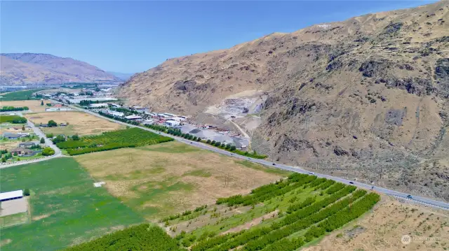 This aerial view from over the ranch house highlights the large example of land for sale but also the close proximity to commercial zoning at the intersection just to the north of the property.  That is US 2/97 highway with Lake Chelan to the north and Wenatchee to the south