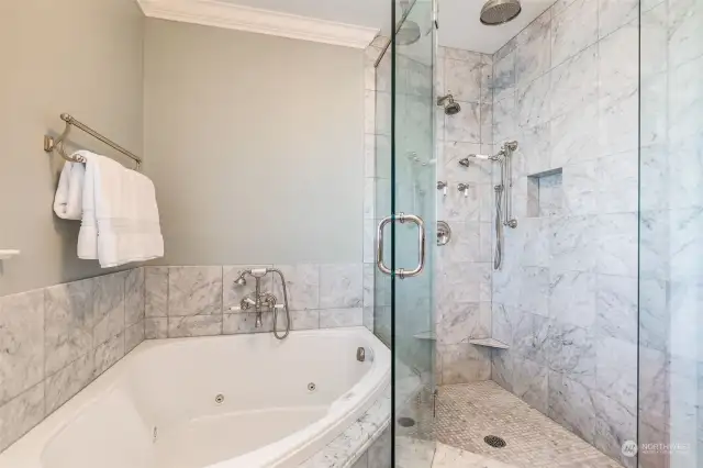 The spa inspired bath features a Carerra marble walk-in shower as well as a jetted tub.