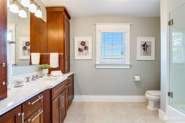 The upstairs hall bath is almost as luxe as the primary, with a large vanity wall for plenty of cabinet space, and a tub/shower that was just refreshed with new opal slab surround and glass door.