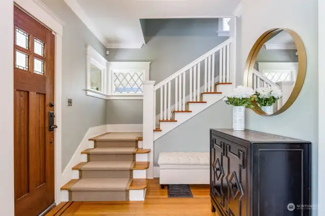 The formal entry with a perfect spot for a bench and a console cabinet.  Note the original diamond pane windows along the stairway.