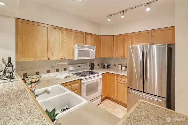 Kitchen is spacious and open a newer stainless Samsung fridge, GE oven/range & microwave, newer GE dishwasher.