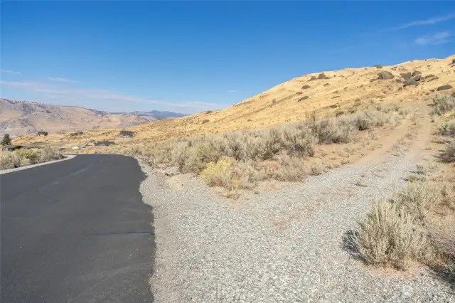 Looking North from the maintained, paved road. Driveway to the property is on the right.