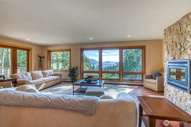 Living room has doors to the deck to the left, a wood fireplace for cozy evenings and wonderful views