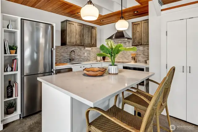 Stylish kitchen has stunning tile backsplash, hi-end wood and lighting accents to create a beautiful space for personal enjoyment and swanky entertaining.