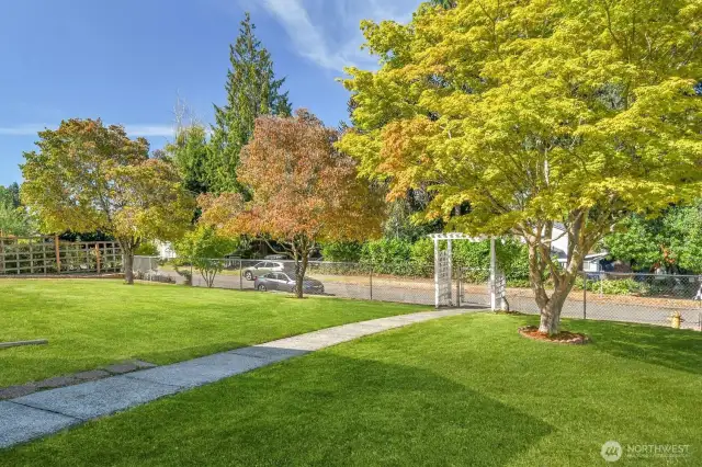 Large front yard, fully fenced with storage buildings and patio.