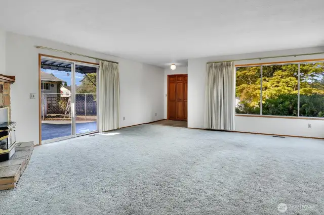 large living room with sliding glass doors to large fenced patio area.