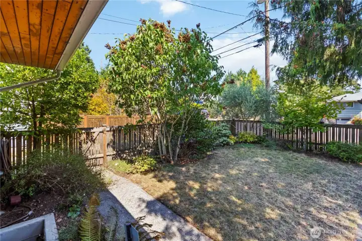 Private fenced front yard with mature landscaping, offering a peaceful enterance to the home.